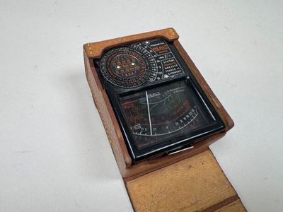 une boîte en bois sur laquelle est posée une horloge, posée sur une surface blanche