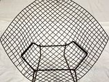 an image of a black wire chair on a white sheet