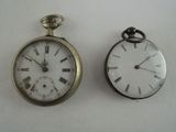 two clocks sitting next to each other on a table
