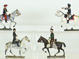 four figurines of people riding horses on display