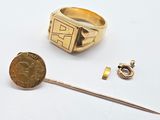 a gold ring with a coin on it next to a pair of scissors