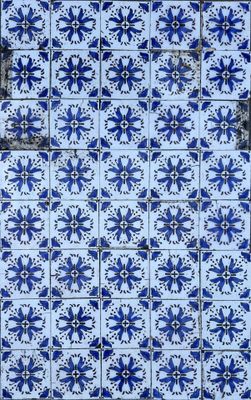 un gros plan sur un mur carrelé de bleu et de blanc, avec une fenêtre