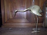 a metal bird that is standing on a table