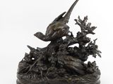 une image représentant une statue en bronze d'un oiseau perché sur une branche d'arbre