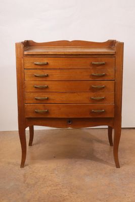 an image of a wooden chest of drawers with brass handles