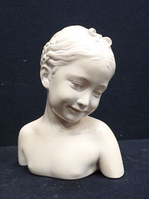 a small white statue of a child on a black surface