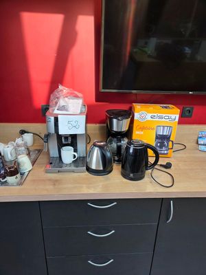 a coffee maker, coffee pot, coffee maker, and other items on the counter