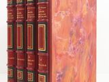 three red books are stacked on top of each other on a white surface
