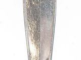 a silver spoon sitting on top of a white table