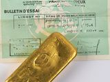 un lingot d'or posé à côté d'un passeport sur une table