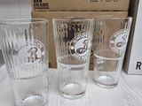 three glasses sitting on a table next to a box of beer