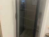 un réfrigérateur à porte vitrée dans un coin de la pièce