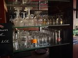 un bar avec de nombreux verres à vin sur les étagères