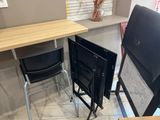 two folding chairs and a table in the corner of a room