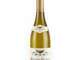 the bottle of white wine is sitting on a white surface