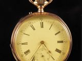 a gold pocket watch with roman numerals on it