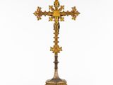 a gold cross on a stand with a cross on top of it