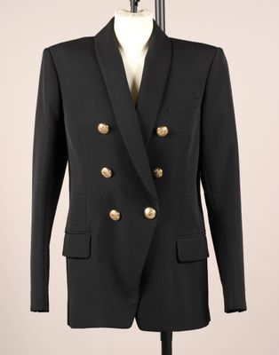 un costume noir avec des boutons dorés sur le revers