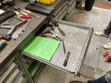 un homme debout devant une table sur laquelle sont posés des outils