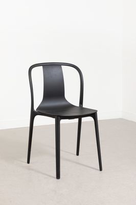 La chaise noire se trouve dans un coin de la pièce.