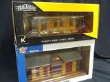 two boxed boxes of toy trains sitting on a black surface