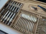 many spoons and forks in a box on the table