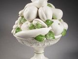 a white bowl filled with fruit and vegetables on a gray surface
