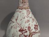 un vase blanc orné d'un motif rouge et blanc