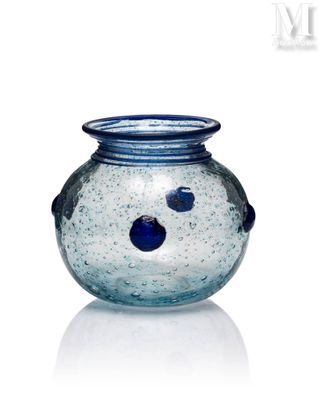 a glass vase with a face on it on a white surface