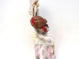 porcelain figurine of a woman holding a vase on a white surface