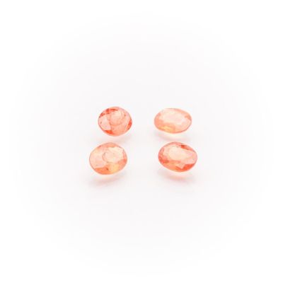 a group of three peach quartz beads on a white background