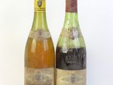 deux bouteilles de vin posées l'une à côté de l'autre sur une surface blanche