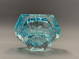 une image représentant un vase en verre bleu posé sur une table