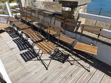 many wooden benches sitting on a deck overlooking the ocean