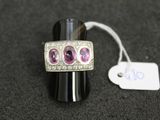 an image of a silver ring with pink stones and a price tag