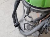 a green and black vacuum on the floor in a room