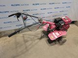 an image of a pink lawn culter in a garage