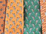 several different colored ties are lined up on a white surface