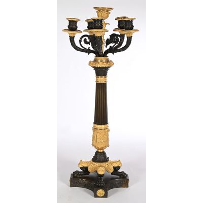 a black and gold candelab with four candles on a pedestal