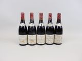 quatre bouteilles de vin sont alignées sur une surface blanche