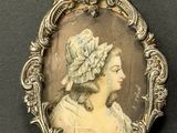 an antique photo of a woman wearing a bonnet in a silver frame