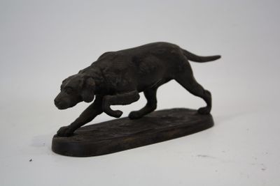 une statue représentant un chien qui court sur une planche