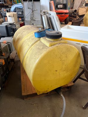 a large yellow tank sitting on a pallet in a warehouse