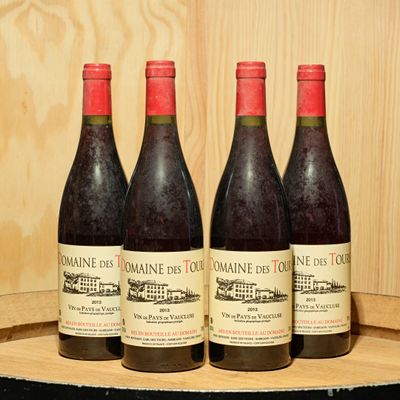 three bottles of wine sit on a barrel in front of a wooden wall
