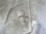 a relief of a man holding a pole in a stone wall