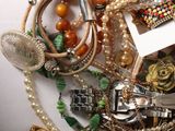 a pile of assorted jewelry on a white surface