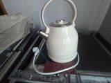 a white tea kettle sitting on top of a stove