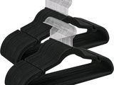 un lot de trois cintres en plastique noir sur fond blanc