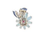 an image of a blue and white broochle with a flower design