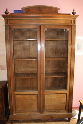 un meuble en bois avec des portes en verre dans le coin d'une pièce